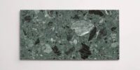 A single marble terrazzo tile in a deep green color