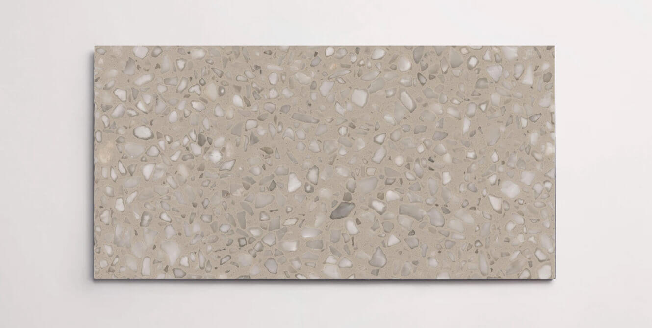 A single taupe terrazzo marble tile with various sized aggregates throughout