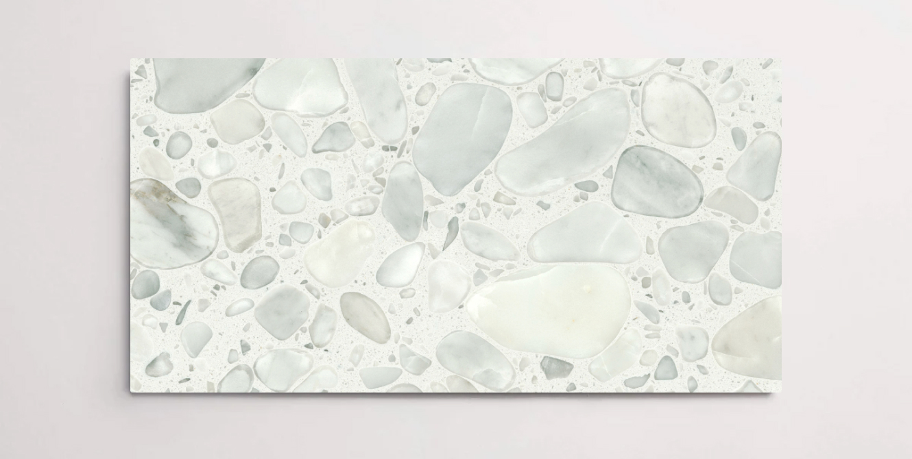 A single white terrazzo marble tile with various sized aggregates throughout in a grey blue color