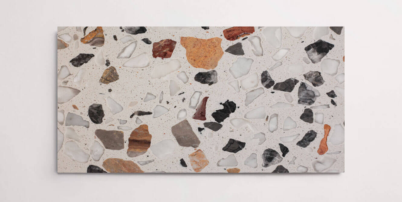 A single grey terrazzo marble tile with various sized multicolor aggregates throughout