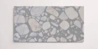 A single grey terrazzo marble tile with various sized aggregates throughout
