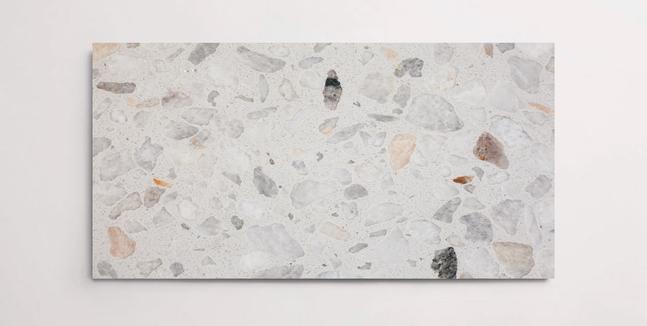 A single taupe colored terrazzo marble tile with various sized aggregates throughout