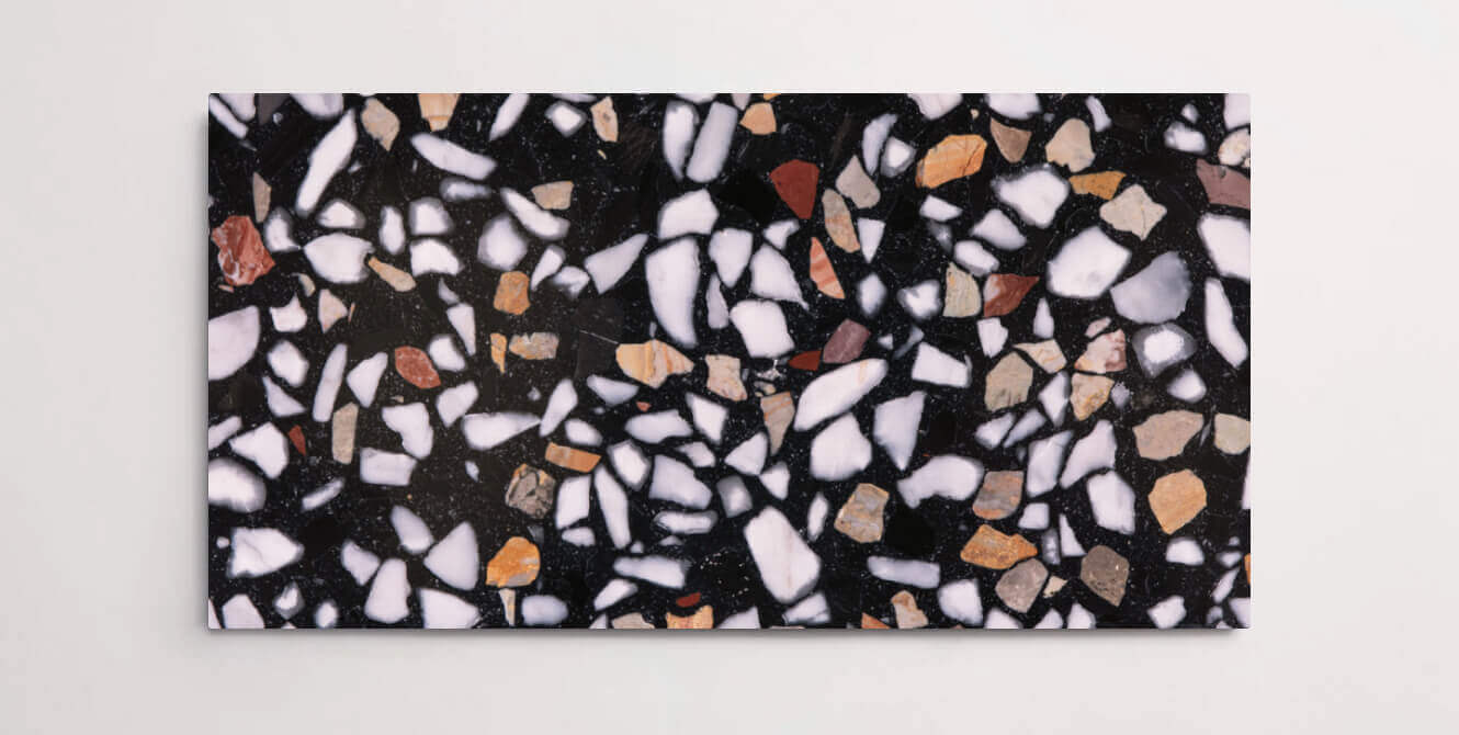 A single black terrazzo marble tile with various sized multicolor chips throughout