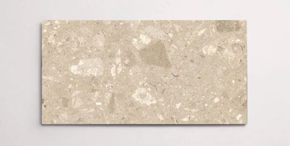 A single beige terrazzo marble tile with various sized aggregates throughout