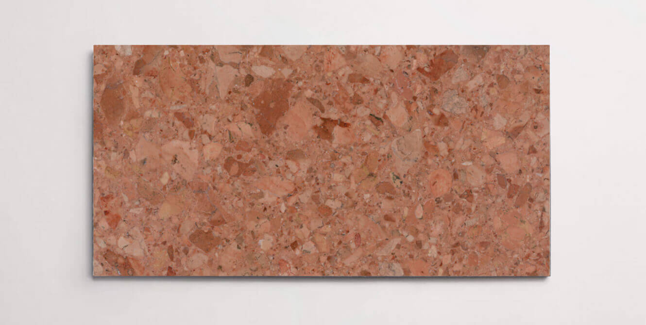 A single red terrazzo marble tile with various sized aggregates throughout