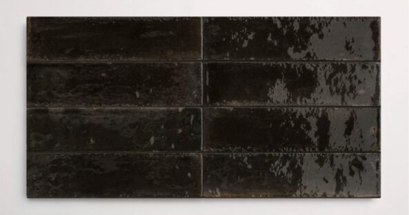 Eight stacked 2.25" x 9.5" black wall tiles in a glossy finish