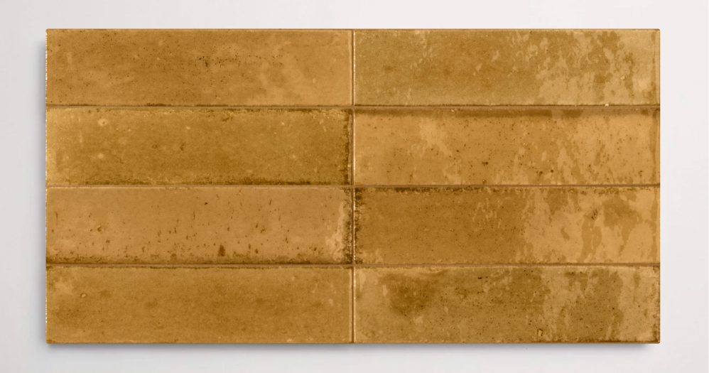 Eight stacked 2.25" x 9.5" golden brown wall tiles in a glossy finish