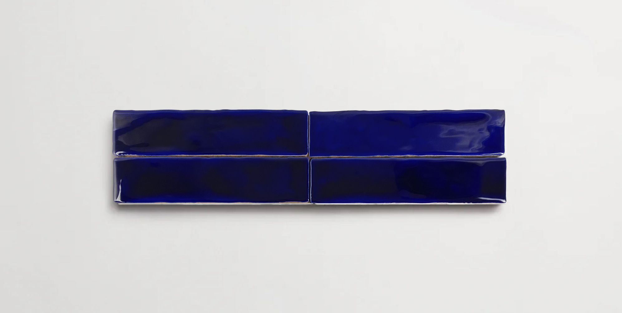 Four stacked 2" x 10" deep blue ceramic tiles in a glossy finish