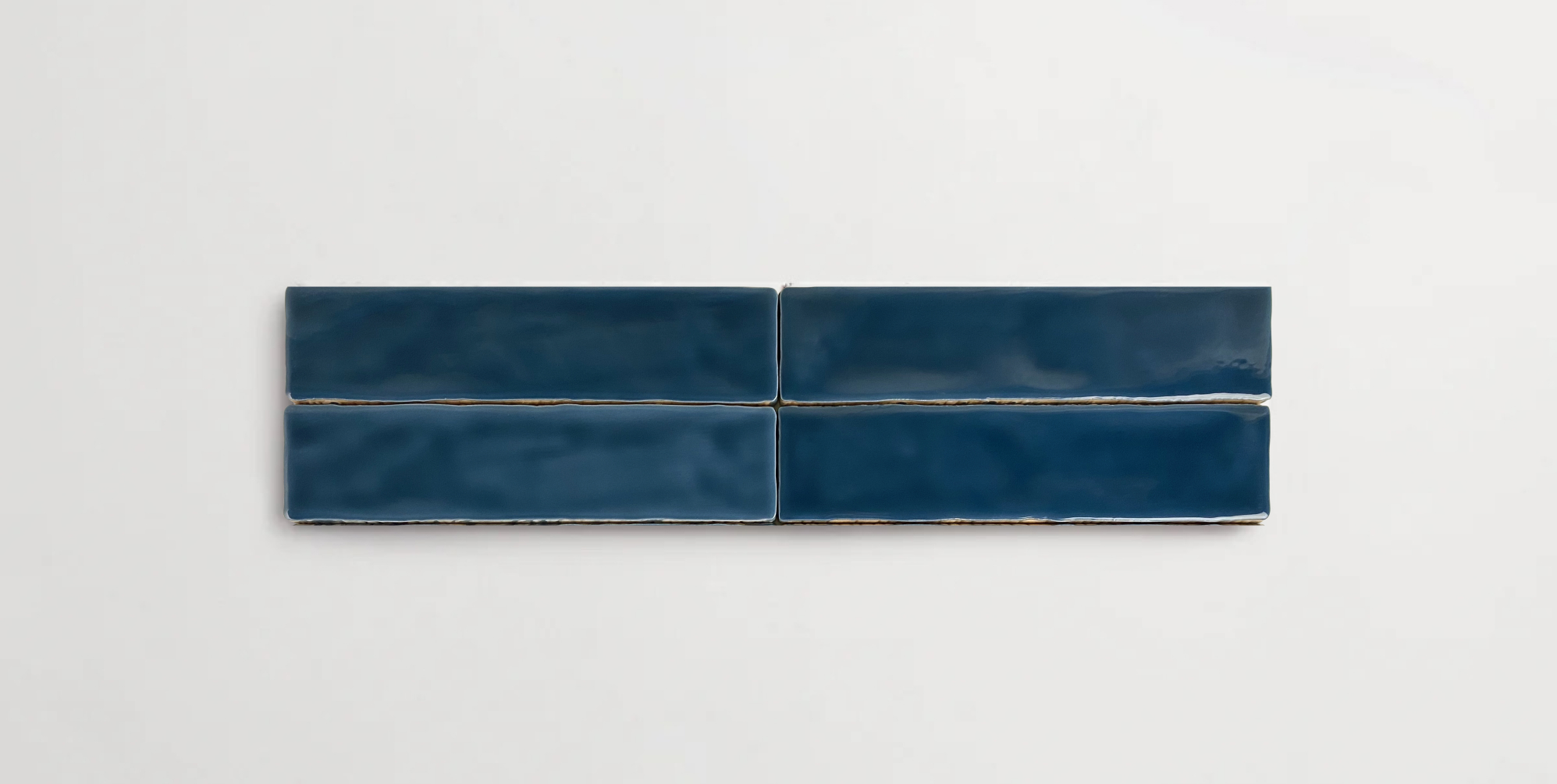 Four stacked 2" x 10" dark blue ceramic tiles in a glossy finish