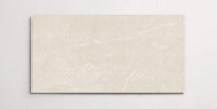 A single cream 10" x 30" porcelain tile resembling stone with a textured finish