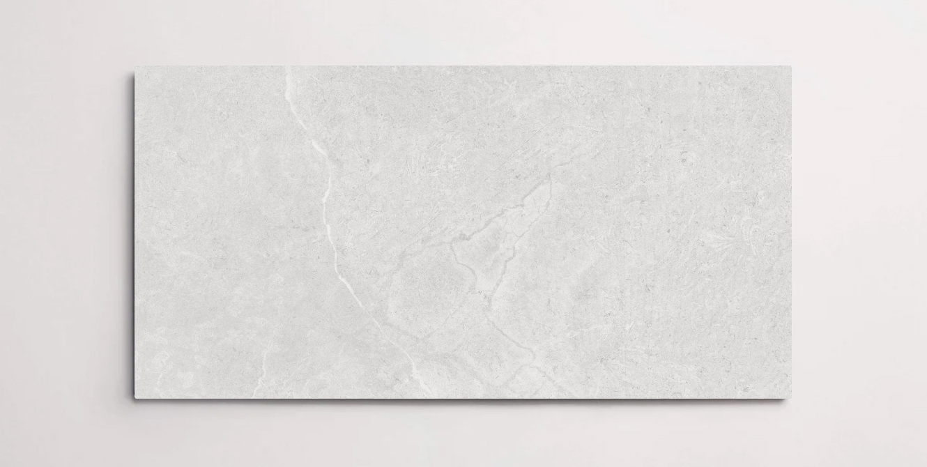 A single white 10" x 30" stone-like porcelain tile with subtle veining