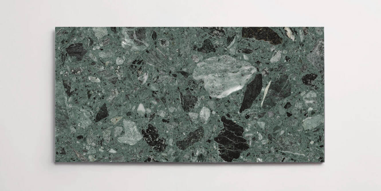 A single marble terrazzo tile in a deep green color