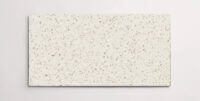 A single cream terrazzo marble tile with small taupe colored chips throughout