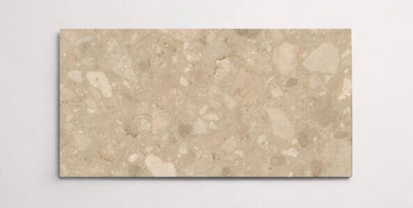 A single beige terrazzo marble tile with various sized aggregates throughout