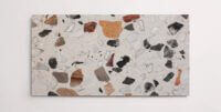 A single grey terrazzo marble tile with various sized multicolor aggregates throughout