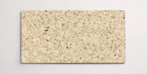 A single beige colored terrazzo marble tile with various sized chips throughout