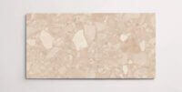 A single blush colored terrazzo marble tile with various sized aggregates throughout