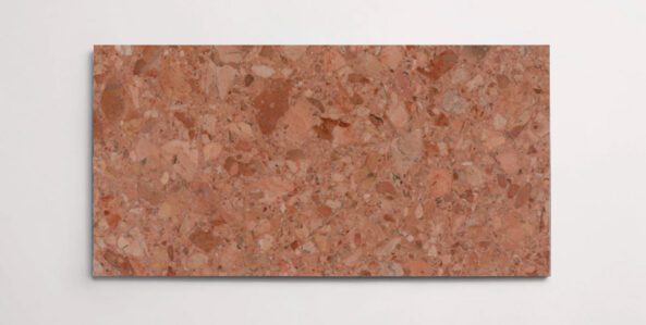 A single red terrazzo marble tile with various sized aggregates throughout