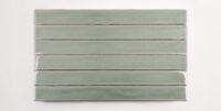 Six stacked 2" x 20" ceramic tiles in a light green color